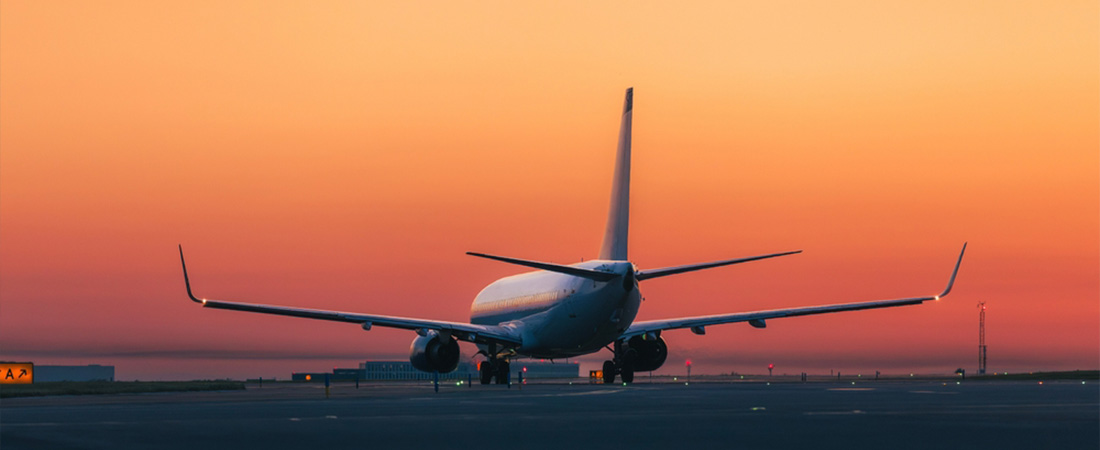 Avión aterrizando en una pista durante la puesta de sol.