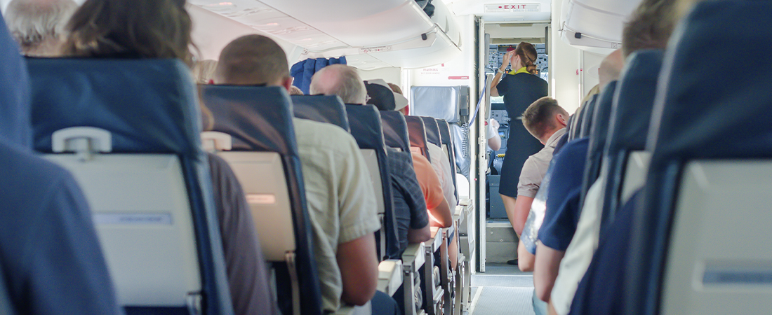 Pasajeros sentados en sus asientos dentro de la cabina del avión esperando el despegue.